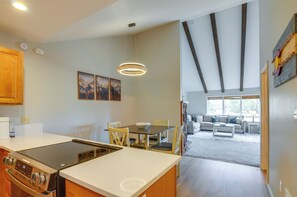 A modern kitchen with a central island, dining area with chairs, and a living room with a sofa and windows. - 4 Mi to Dtwn: Pagosa Springs Gem w/ Mtn Views! (Pagosa Springs)