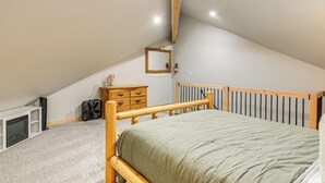 A bedroom with a sloped ceiling, a bed with a wooden headboard, a dresser, a mirror, and a radiator. - 4 Mi to Dtwn: Pagosa Springs Gem w/ Mtn Views! (Pagosa Springs)