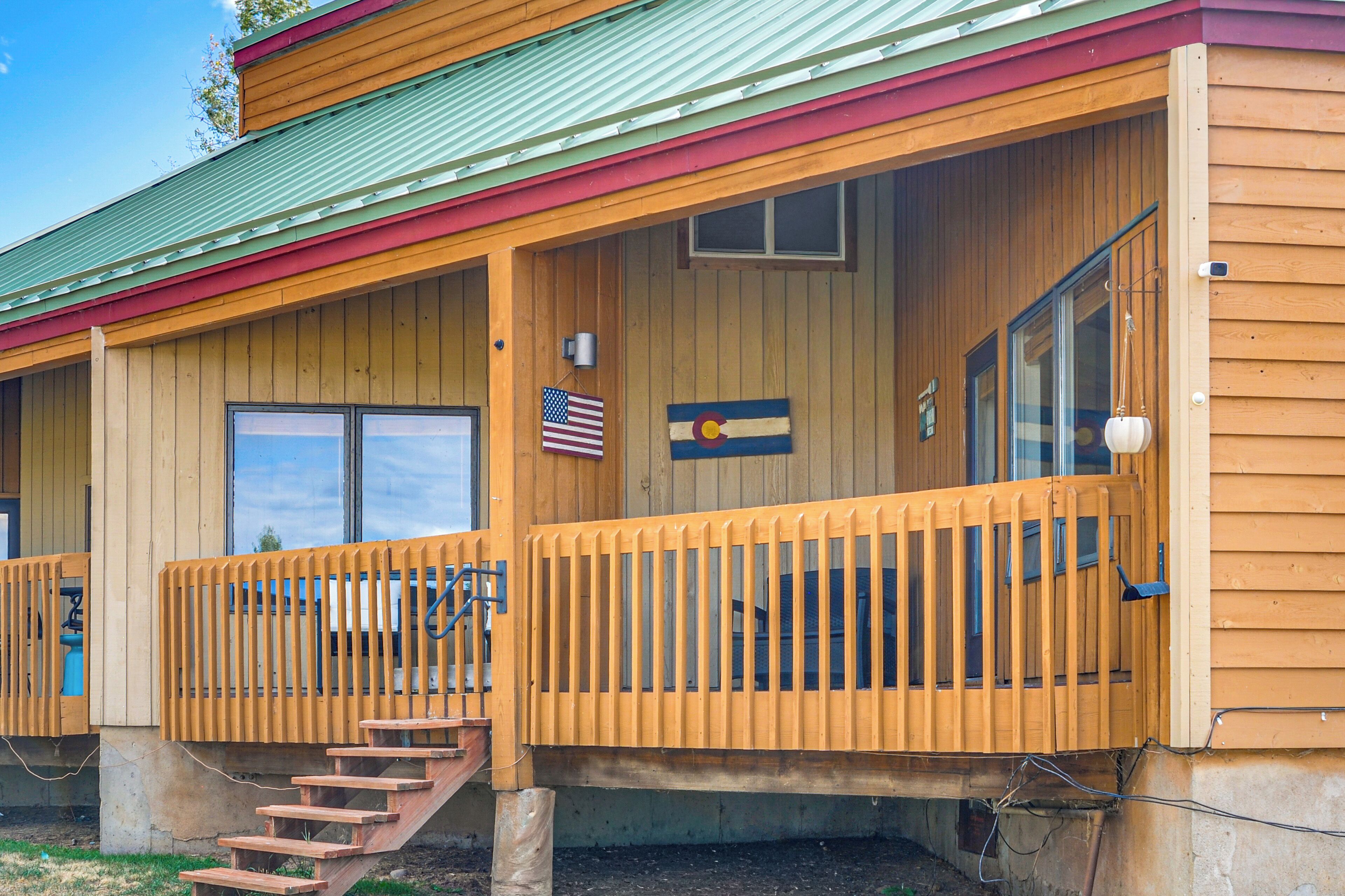 A wooden building with a porch, a flag, and a flag with a state emblem.