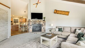 A living room with a fireplace, a sofa, a coffee table, and a television mounted on the wall. - 4 Mi to Dtwn: Pagosa Springs Gem w/ Mtn Views! (Pagosa Springs)