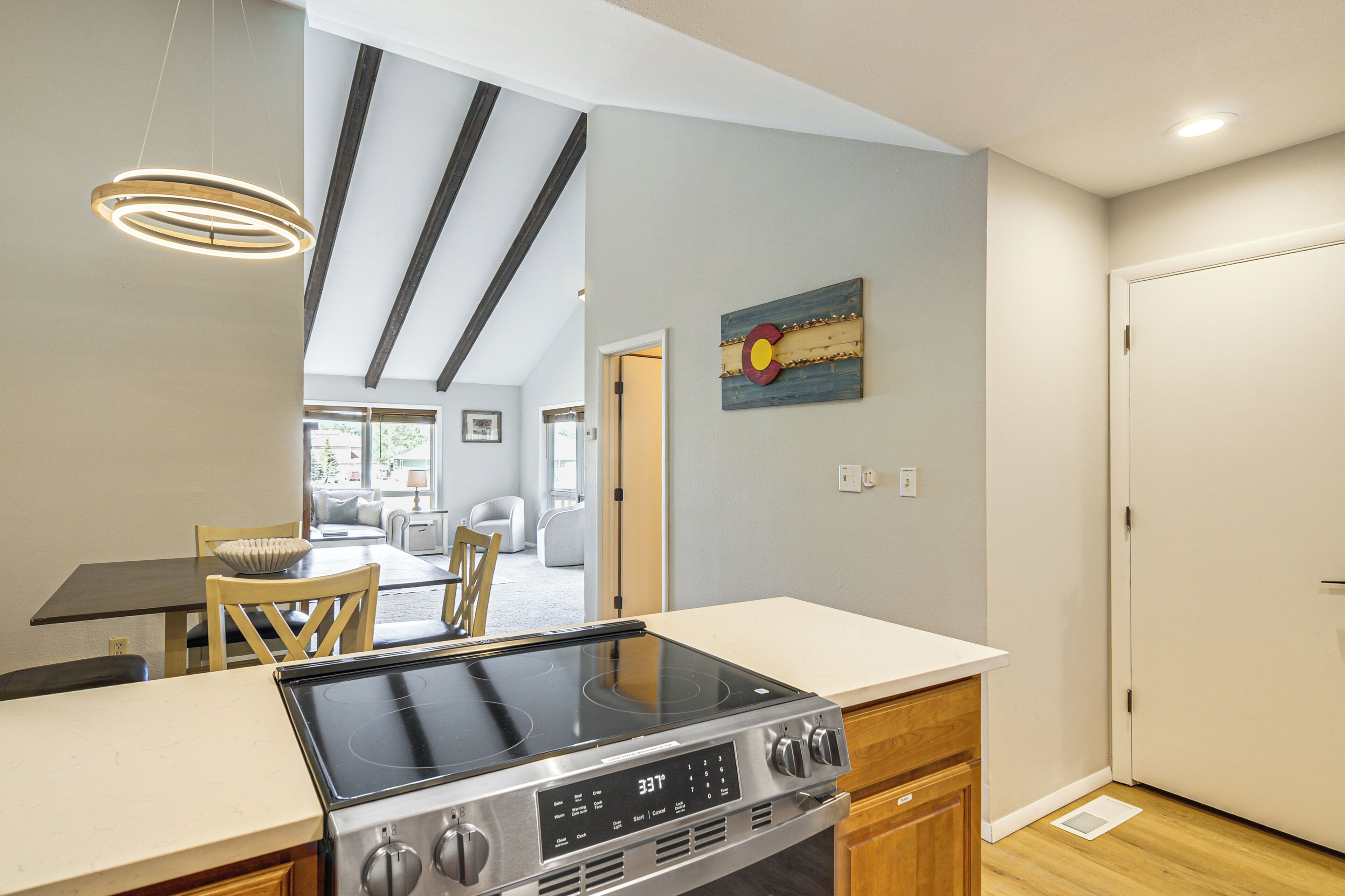 Une cuisine moderne dotée d’une plaque de cuisson intégrée, de meubles en bois et d’un coin repas avec une table et des chaises.
