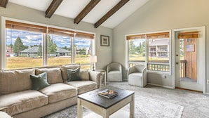 A living room with a sofa, a coffee table, and a chair. There are large windows with blinds, a picture on the wall, and a view of houses outside. - 4 Mi to Dtwn: Pagosa Springs Gem w/ Mtn Views! (Pagosa Springs)