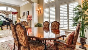 A formal dining room with a large wooden table, ornate chairs, and a piano in the background. - Upscale Group Getaway in Orem w/ Private Hot Tub (Orem)