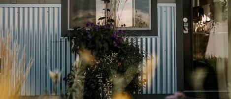 Un bâtiment avec une fenêtre, une porte portant l’inscription « CUISINE » et un panneau indiquant « RÉSERVÉ AUX CLIENTS ENREGISTRÉS ».