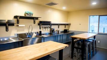 A kitchen with a sink, stove, and wooden table.