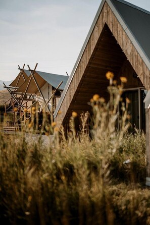 A modern building with a triangular roof and wooden exterior. - Cute A-Frame Cabin for an Amazing Couples Getaway near Yellowstone National Park in Emigrant, Montana (Emigrant)