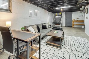 A modern living space with a sofa, coffee table, and a dining table. - Pet-friendly Oakley Gem w/ Large Backyard! (Cincinnati)