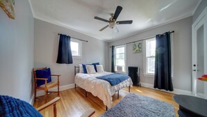 A bedroom with a bed, a chair, a ceiling fan, and a window. - Deck, Pool Table! Walkable Cleveland Heights Apt (Cleveland Heights)