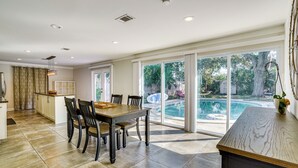 A spacious kitchen with a dining area, large windows, and a view of a swimming pool. - Convenient Oasis in St Pete, 4 Mi to Pier & Dtwn! (St. Petersburg)