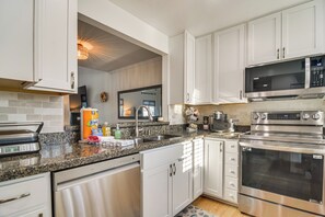 A modern kitchen with white cabinets, stainless steel appliances, and a granite countertop. - 1 Block to Sunset Beach: Dog-friendly Family Home (Treasure Island)