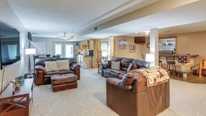 A spacious living area with a large brown leather sofa, a dining table, and a kitchen in the background. - Work & Relax! Spacious Ontario Home w/ Pool (Mansfield)