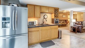 A modern kitchen with stainless steel appliances, wooden cabinets, and a central island. - Work & Relax! Spacious Ontario Home w/ Pool (Mansfield)