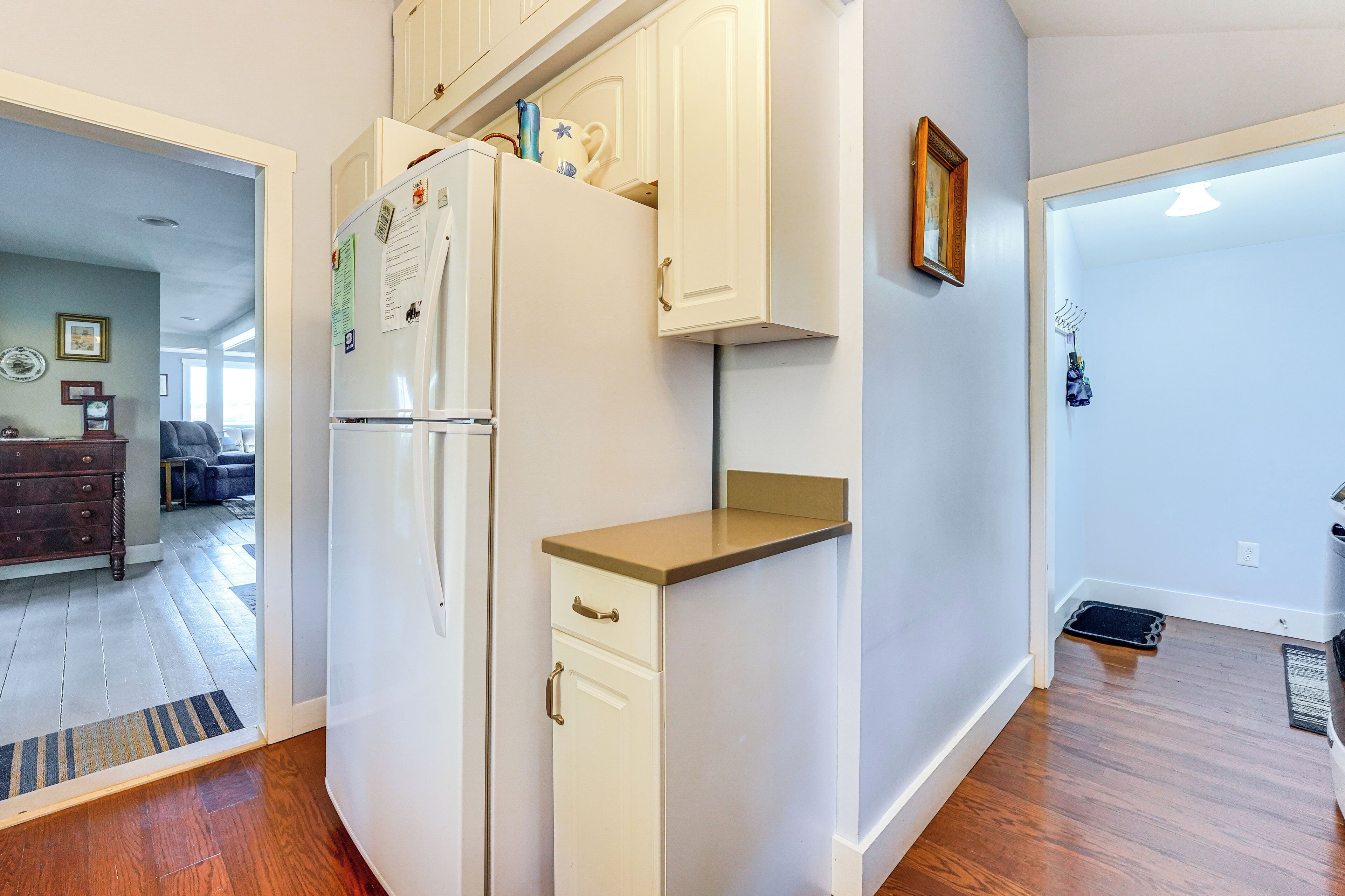 A kitchen with white cabinets, a refrigerator, and a countertop.