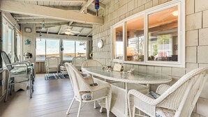 A cozy dining area with wicker furniture and a glass table, overlooking a scenic view. - River Access! Penobscot Retreat 5 Mi to Fort Knox (Stockton Springs)