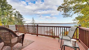 A wooden deck with wicker chairs and a table, overlooking a body of water and trees. - River Access! Penobscot Retreat 5 Mi to Fort Knox (Stockton Springs)