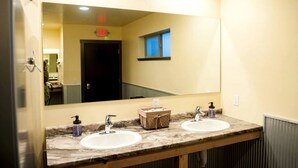 Un baño con dos lavamanos, un espejo y una ventana.