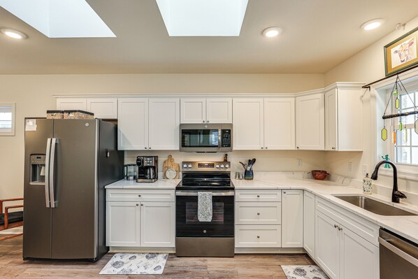 A modern kitchen with white cabinets, stainless steel appliances, and a skylight. - Walk to Historic Chestertown: Dog-friendly Retreat (Chestertown)