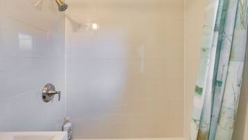 A bathroom with a shower, a bathtub, and a toilet.