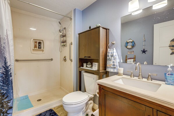 A bathroom with a shower, toilet, and sink. - 'kokomo Kove' - Waterfront Country Texas Getaway (Livingston)
