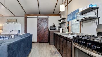 A compact living space with a kitchenette, a sofa, and a dining area.