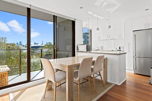 Una cocina moderna con una isla grande, armarios blancos y vistas a la ciudad.