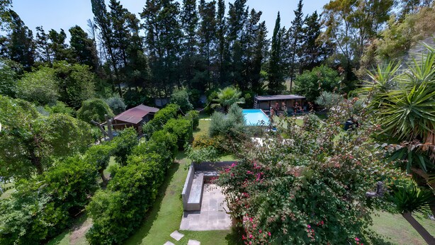 Una propiedad residencial con piscina, zona de patio y jardín bien cuidado.