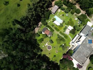 Eine Vogelperspektive auf ein Wohnhaus mit Swimmingpool, einem eingezäunten Garten und einer separaten Garage.