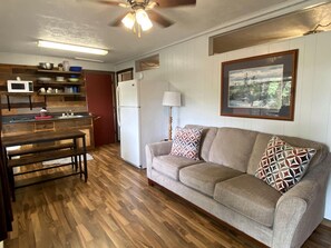 A living room with a sofa, a wooden bench, a lamp, and a painting on the wall. - Exquisite and Spacious Vacation Rental in Branson, MO (Branson)