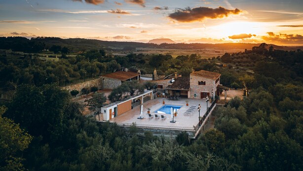 A villa with a swimming pool, outdoor seating, and a view of the surrounding landscape. - Country House 'Sunshine' with Mountain View, Wi-Fi and Air Conditioning (Sant Joan)