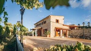 A stone building with arched windows and a paved entrance. - Country House 'Sunshine' with Mountain View, Wi-Fi and Air Conditioning (Sant Joan)