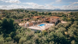 A villa with a swimming pool, surrounded by olive trees and a stone wall. - Country House 'Sunshine' with Mountain View, Wi-Fi and Air Conditioning (Sant Joan)