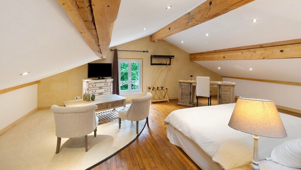 Une chambre à coucher avec un lit, un bureau, une chaise, une télévision et une fenêtre.