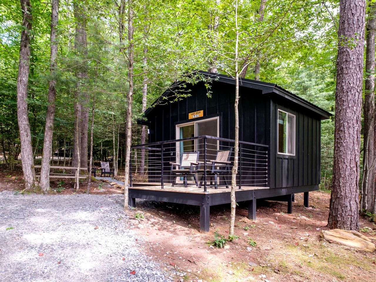 Une cabane avec une terrasse, deux chaises et une pancarte sur laquelle on peut lire : « DERNIER RUGISSEMENT 188 ».