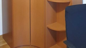 Un armario de madera con dos puertas y varios estantes.