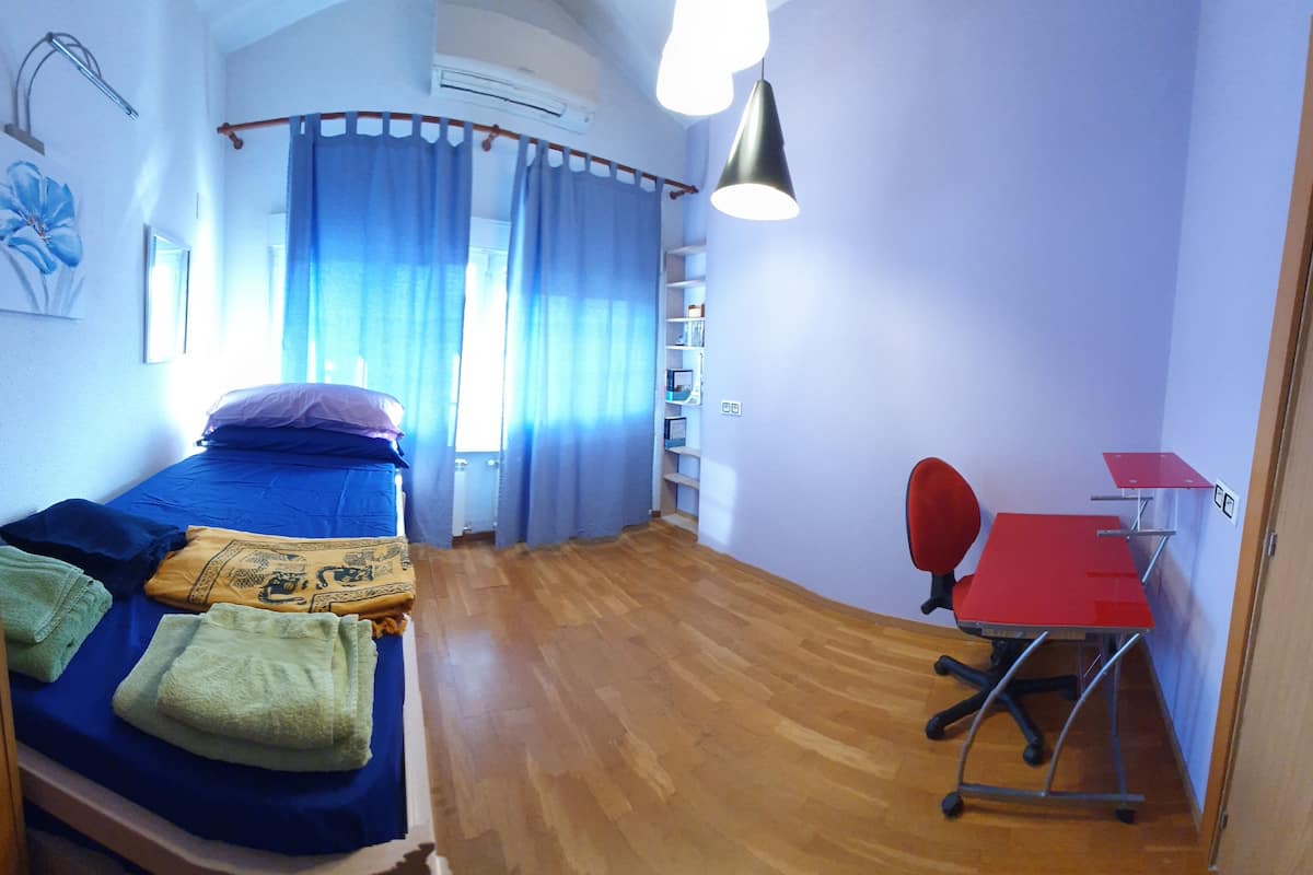 Ein Schlafzimmer mit einem Bett, einem Schreibtisch und einem Stuhl.