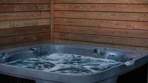 A hot tub with a wooden wall background. - Luxury Living with Panoramic Views at Cherry Log's Designer Dome (Cherry Log)