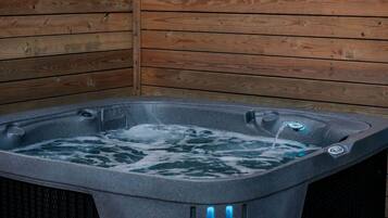 A hot tub with a wooden wall background.