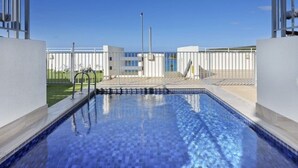 A swimming pool with a clear view of the surrounding area, including a building with a modern design and a fenced area. - Beachside Paradise - Ocean Views, Central Position (Sydney)