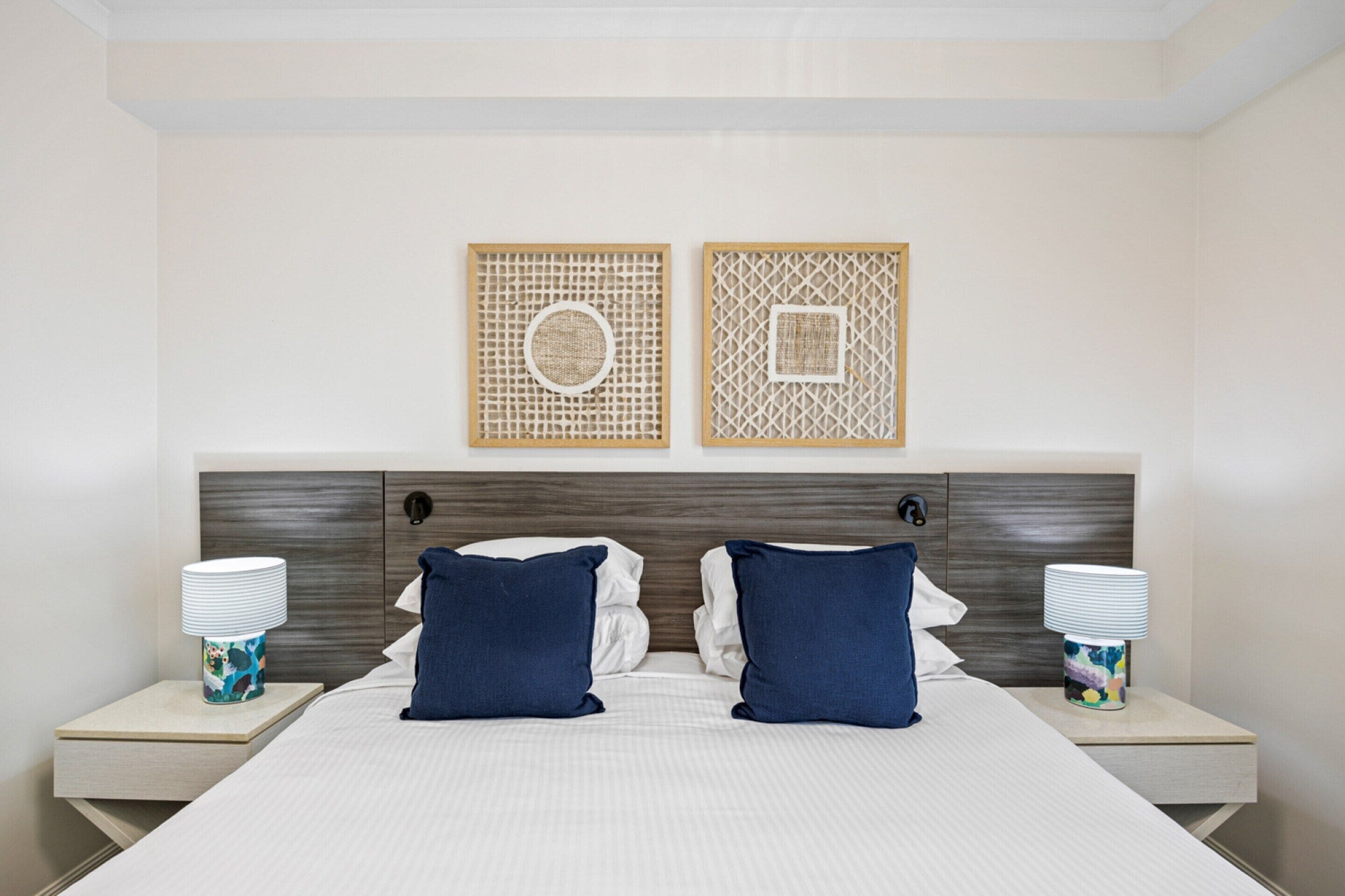 Una camera d'albergo con un letto grande, due comodini e due lampade a parete.