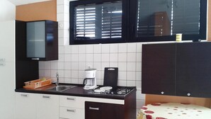 A kitchen with a coffee maker, a sink, and cabinets. - Apartment in Jadranovo With Parking Space (Crikvenica)