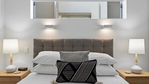 A neatly arranged bedroom with a large bed, two bedside tables, a headboard, and a mirror above the bed. - Chic 2-bed Apartment & 5 Minutes Walk to Qpac (Brisbane)