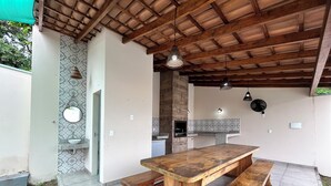A wooden table with benches, a tiled floor, a ceiling with wooden beams, and a wall with a patterned backsplash. - Excellent 5-bedroom house with pool in the center of Prado! (Prado)