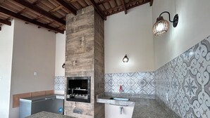 Eine Küche mit Einbauofen, Granit-Arbeitsplatten, einer gemusterten Spritzschutzwand und einer Holzbalkendecke.