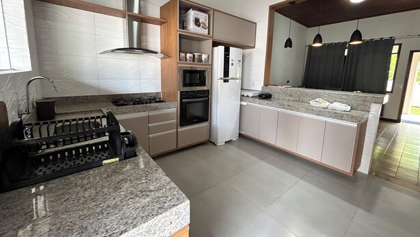 Eine moderne Küche mit Granit-Arbeitsplatten, Edelstahlgeräten und Holzschränken.