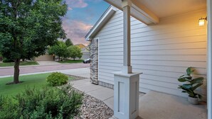 A residential house with a covered porch, a stone pillar, and a potted plant. - Fountain Family Retreat | Pet Friendly (Fountain)
