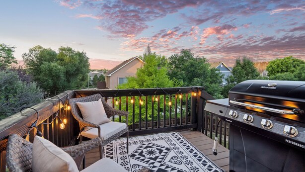 A deck with outdoor furniture, a grill, and string lights. - Fountain Family Retreat | Pet Friendly (Fountain)
