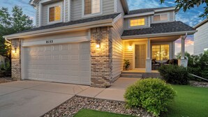 A two-story house with a garage, stone accents, and a well-lit entrance. - Fountain Family Retreat | Pet Friendly (Fountain)