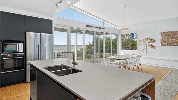 A modern kitchen with a large island, built-in appliances, and a view of the outdoors. - Riverside Retreat - Waterfront - Hindmarsh Island (Hindmarsh Island)