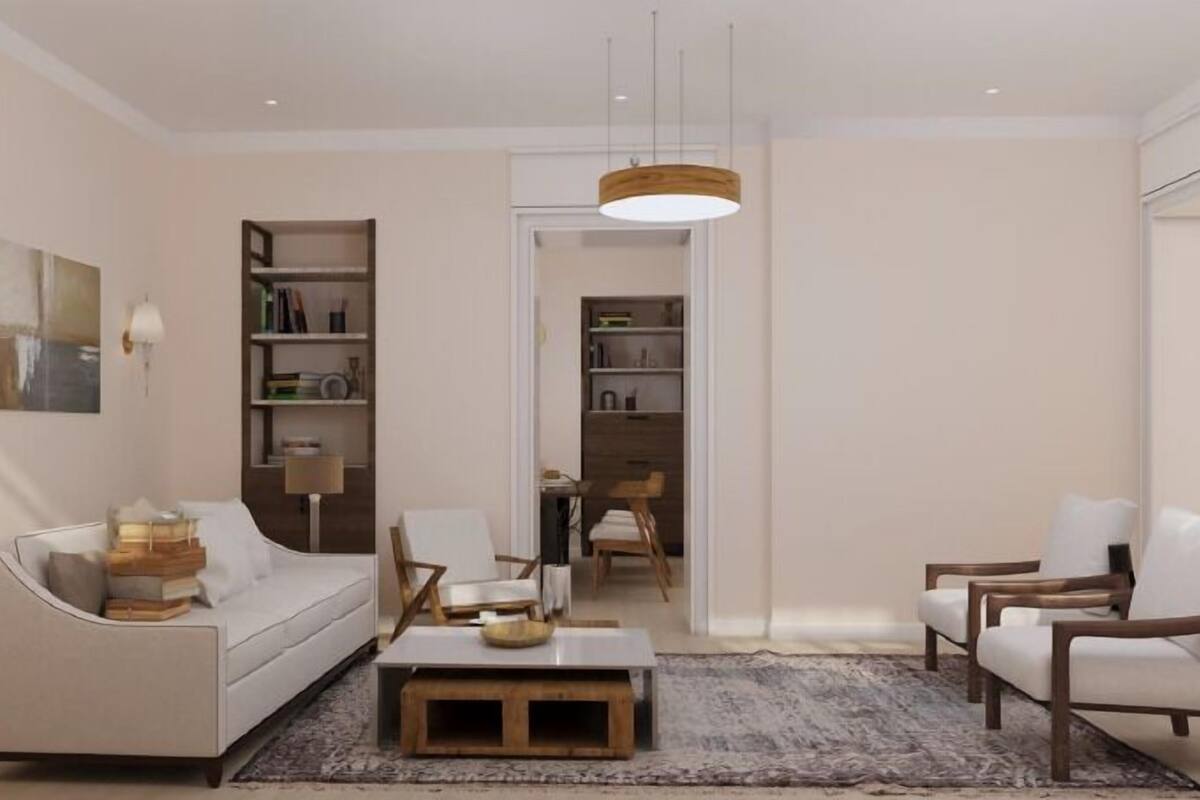 A modern living room with a sofa, armchairs, a coffee table, and a bookshelf.