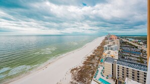 Ein Hotel direkt am Strand mit Blick auf das Meer, einem Sandstrand und einem Parkplatz.